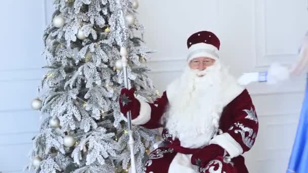 Święty Mikołaj i Snow Maiden z prezentem w pobliżu choinki w nowym roku — Wideo stockowe