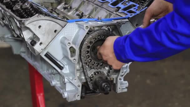 Las manos mecánicas aprietan la tuerca con llave inglesa mientras reparan el motor — Vídeos de Stock