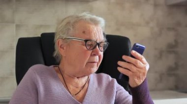 Yaşlı bir kadın, cep telefonu olan bir büyükanne.