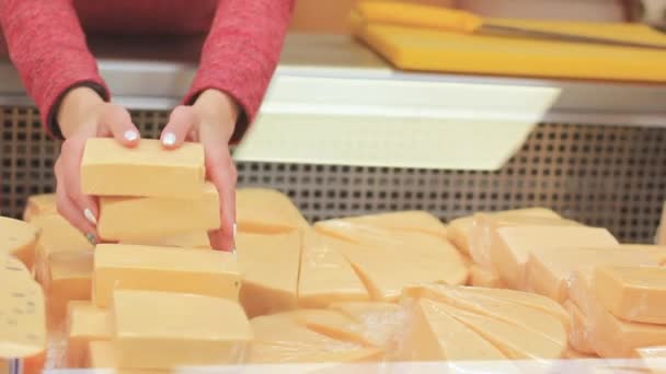 Las manos femeninas clasifican el queso en el equipo de refrigeración de la tienda. — Vídeo de stock