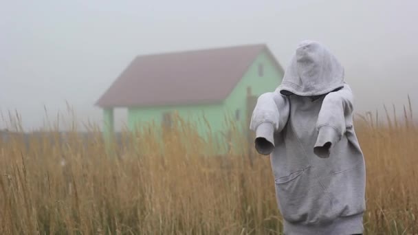 Fantôme joyeux dans le brouillard dans une cagoule près d'une maison abandonnée — Video