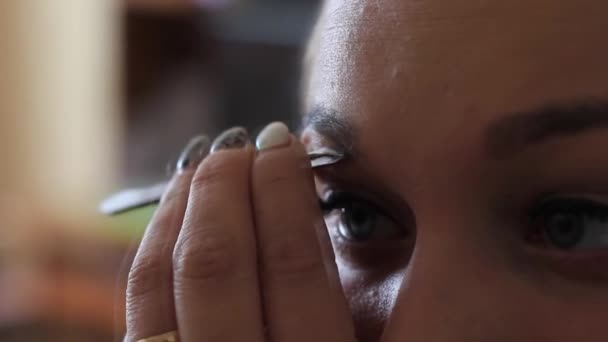 Jeune femme arrachant les sourcils avec une pince à épiler fermer — Video