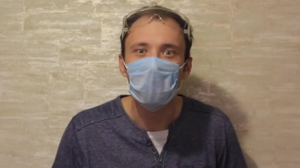 Crazy guy during the virus in a medical mask and special glasses. — Stock Video