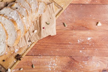 Taze ve güzel kokulu beyaz ekmek dilimlenmiş ve bir ahşap zemin üzerine yalancı. Biraz baharat kendisine eklenmiş ve aynı zamanda kraft kağıt üzerinde yatıyor. Gluten-Alerjik. Kavramsal gıda fotoğraf.