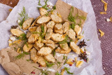 Huysuz ve güzel kokulu beyaz kruton kızarmış ve yalancı bir ahşap zemin üzerinde. Biraz baharat kendisine eklenmiş ve aynı zamanda kraft kağıt üzerinde yatıyor. Gluten-Alerjik. Kavramsal gıda fotoğraf.