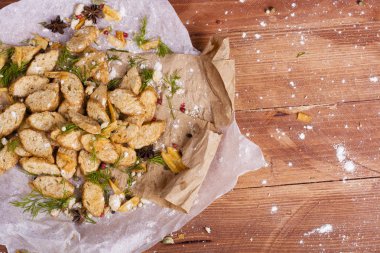 Huysuz ve güzel kokulu beyaz kruton kızarmış ve yalancı bir ahşap zemin üzerinde. Biraz baharat kendisine eklenmiş ve aynı zamanda kraft kağıt üzerinde yatıyor. Gluten-Alerjik. Kavramsal gıda fotoğraf.