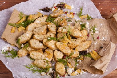 Huysuz ve güzel kokulu beyaz kruton kızarmış ve yalancı bir ahşap zemin üzerinde. Biraz baharat kendisine eklenmiş ve aynı zamanda kraft kağıt üzerinde yatıyor. Gluten-Alerjik. Kavramsal gıda fotoğraf.