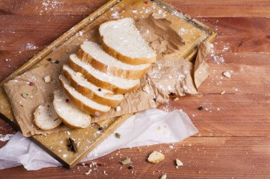 Taze ve güzel kokulu beyaz ekmek dilimlenmiş ve bir ahşap zemin üzerine yalancı. Biraz baharat kendisine eklenmiş ve aynı zamanda kraft kağıt üzerinde yatıyor. Gluten-Alerjik. Kavramsal gıda fotoğraf.