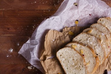 Taze ve güzel kokulu beyaz ekmek dilimlenmiş ve bir ahşap zemin üzerine yalancı. Biraz baharat kendisine eklenmiş ve aynı zamanda kraft kağıt üzerinde yatıyor. Gluten-Alerjik. Kavramsal gıda fotoğraf.