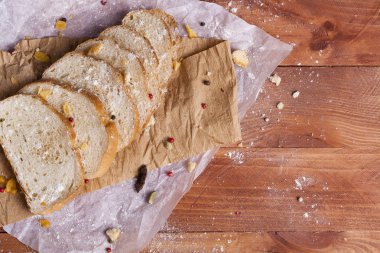Taze ve güzel kokulu beyaz ekmek dilimlenmiş ve bir ahşap zemin üzerine yalancı. Biraz baharat kendisine eklenmiş ve aynı zamanda kraft kağıt üzerinde yatıyor. Gluten-Alerjik. Kavramsal gıda fotoğraf.