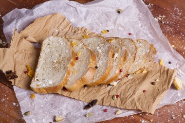 Taze ve güzel kokulu beyaz ekmek dilimlenmiş ve bir ahşap zemin üzerine yalancı. Biraz baharat kendisine eklenmiş ve aynı zamanda kraft kağıt üzerinde yatıyor. Gluten-Alerjik. Kavramsal gıda fotoğraf.