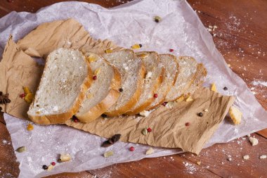 Taze ve güzel kokulu beyaz ekmek dilimlenmiş ve bir ahşap zemin üzerine yalancı. Biraz baharat kendisine eklenmiş ve aynı zamanda kraft kağıt üzerinde yatıyor. Gluten-Alerjik. Kavramsal gıda fotoğraf.