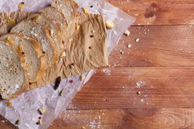 Taze ve güzel kokulu beyaz ekmek dilimlenmiş ve bir ahşap zemin üzerine yalancı. Biraz baharat kendisine eklenmiş ve aynı zamanda kraft kağıt üzerinde yatıyor. Gluten-Alerjik. Kavramsal gıda fotoğraf.