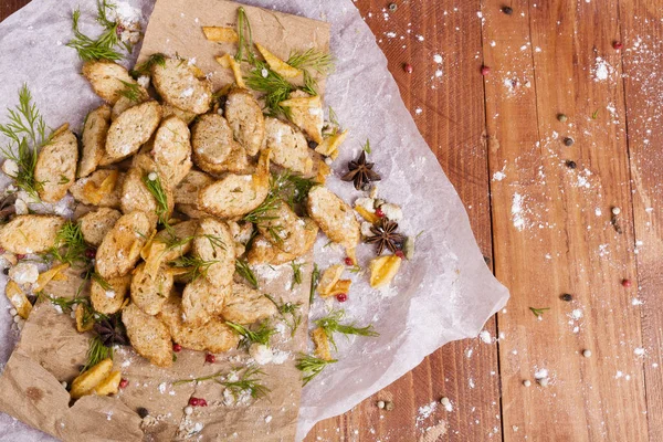 Huysuz ve güzel kokulu beyaz kruton kızarmış ve yalancı bir ahşap zemin üzerinde. Biraz baharat kendisine eklenmiş ve aynı zamanda kraft kağıt üzerinde yatıyor. Gluten-Alerjik. Kavramsal gıda fotoğraf.