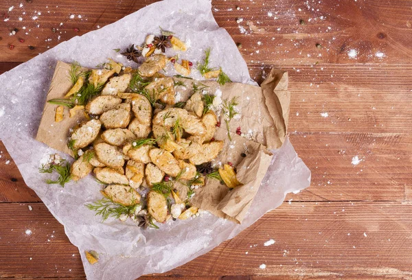 Huysuz ve güzel kokulu beyaz kruton kızarmış ve yalancı bir ahşap zemin üzerinde. Biraz baharat kendisine eklenmiş ve aynı zamanda kraft kağıt üzerinde yatıyor. Gluten-Alerjik. Kavramsal gıda fotoğraf.