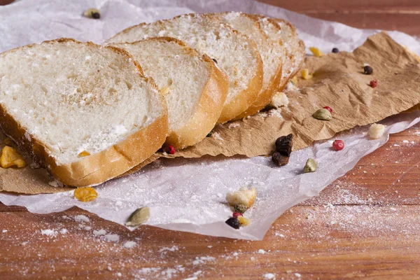 Taze ve güzel kokulu beyaz ekmek dilimlenmiş ve bir ahşap zemin üzerine yalancı. Biraz baharat kendisine eklenmiş ve aynı zamanda kraft kağıt üzerinde yatıyor. Gluten-Alerjik. Kavramsal gıda fotoğraf.