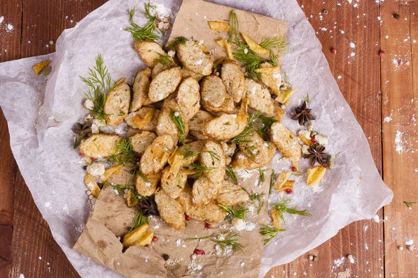 Huysuz ve güzel kokulu beyaz kruton kızarmış ve yalancı bir ahşap zemin üzerinde. Biraz baharat kendisine eklenmiş ve aynı zamanda kraft kağıt üzerinde yatıyor. Gluten-Alerjik. Kavramsal gıda fotoğraf.