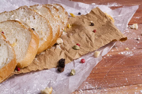 Taze ve güzel kokulu beyaz ekmek dilimlenmiş ve bir ahşap zemin üzerine yalancı. Biraz baharat kendisine eklenmiş ve aynı zamanda kraft kağıt üzerinde yatıyor. Gluten-Alerjik. Kavramsal gıda fotoğraf.