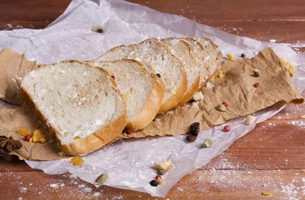 Taze ve güzel kokulu beyaz ekmek dilimlenmiş ve bir ahşap zemin üzerine yalancı. Biraz baharat kendisine eklenmiş ve aynı zamanda kraft kağıt üzerinde yatıyor. Gluten-Alerjik. Kavramsal gıda fotoğraf.