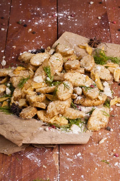 Huysuz ve güzel kokulu beyaz kruton kızarmış ve yalancı bir ahşap zemin üzerinde. Biraz baharat kendisine eklenmiş ve aynı zamanda kraft kağıt üzerinde yatıyor. Gluten-Alerjik. Kavramsal gıda fotoğraf.