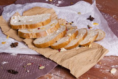Taze ve güzel kokulu beyaz ekmek dilimlenmiş ve bir ahşap zemin üzerine yalancı. Biraz baharat kendisine eklenmiş ve aynı zamanda kraft kağıt üzerinde yatıyor. Gluten-Alerjik. Kavramsal gıda fotoğraf.