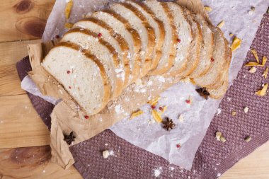 Taze ve güzel kokulu beyaz ekmek dilimlenmiş ve bir ahşap zemin üzerine yalancı. Biraz baharat kendisine eklenmiş ve aynı zamanda kraft kağıt üzerinde yatıyor. Gluten-Alerjik. Kavramsal gıda fotoğraf.