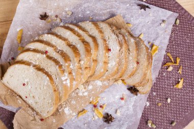 Taze ve güzel kokulu beyaz ekmek dilimlenmiş ve bir ahşap zemin üzerine yalancı. Biraz baharat kendisine eklenmiş ve aynı zamanda kraft kağıt üzerinde yatıyor. Gluten-Alerjik. Kavramsal gıda fotoğraf.