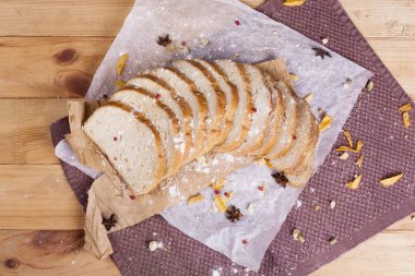 Taze ve güzel kokulu beyaz ekmek dilimlenmiş ve bir ahşap zemin üzerine yalancı. Biraz baharat kendisine eklenmiş ve aynı zamanda kraft kağıt üzerinde yatıyor. Gluten-Alerjik. Kavramsal gıda fotoğraf.