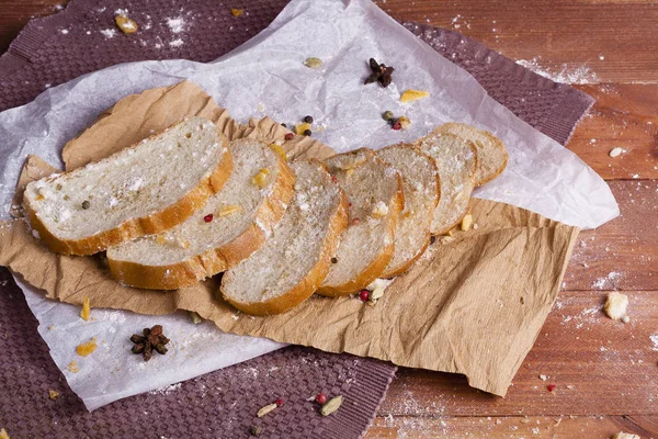 Taze ve güzel kokulu beyaz ekmek dilimlenmiş ve bir ahşap zemin üzerine yalancı. Biraz baharat kendisine eklenmiş ve aynı zamanda kraft kağıt üzerinde yatıyor. Gluten-Alerjik. Kavramsal gıda fotoğraf.