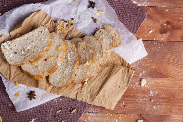 Taze ve güzel kokulu beyaz ekmek dilimlenmiş ve bir ahşap zemin üzerine yalancı. Biraz baharat kendisine eklenmiş ve aynı zamanda kraft kağıt üzerinde yatıyor. Gluten-Alerjik. Kavramsal gıda fotoğraf.