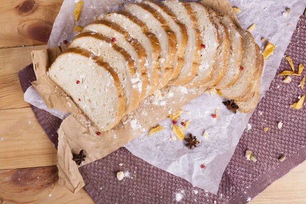 Taze ve güzel kokulu beyaz ekmek dilimlenmiş ve bir ahşap zemin üzerine yalancı. Biraz baharat kendisine eklenmiş ve aynı zamanda kraft kağıt üzerinde yatıyor. Gluten-Alerjik. Kavramsal gıda fotoğraf.