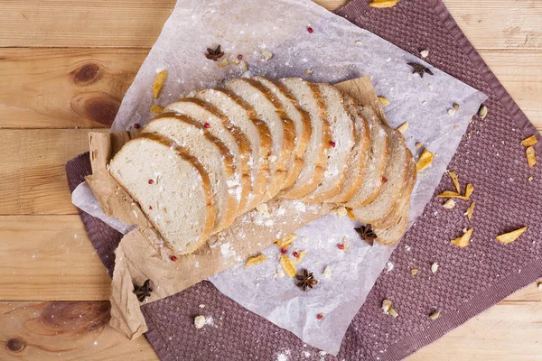 Taze ve güzel kokulu beyaz ekmek dilimlenmiş ve bir ahşap zemin üzerine yalancı. Biraz baharat kendisine eklenmiş ve aynı zamanda kraft kağıt üzerinde yatıyor. Gluten-Alerjik. Kavramsal gıda fotoğraf.
