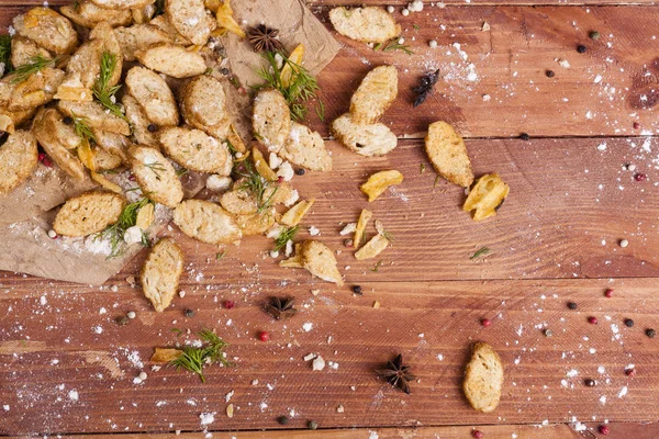 Huysuz ve güzel kokulu beyaz kruton kızarmış ve yalancı bir ahşap zemin üzerinde. Biraz baharat kendisine eklenmiş ve aynı zamanda kraft kağıt üzerinde yatıyor. Gluten-Alerjik. Kavramsal gıda fotoğraf.