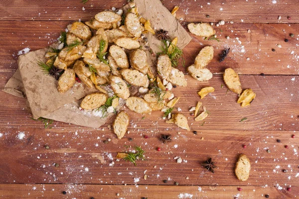 Huysuz ve güzel kokulu beyaz kruton kızarmış ve yalancı bir ahşap zemin üzerinde. Biraz baharat kendisine eklenmiş ve aynı zamanda kraft kağıt üzerinde yatıyor. Gluten-Alerjik. Kavramsal gıda fotoğraf.