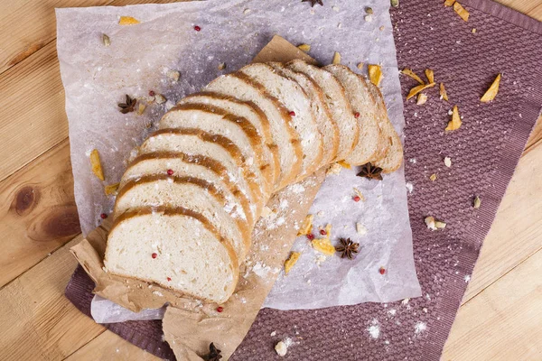 Taze ve güzel kokulu beyaz ekmek dilimlenmiş ve bir ahşap zemin üzerine yalancı. Biraz baharat kendisine eklenmiş ve aynı zamanda kraft kağıt üzerinde yatıyor. Gluten-Alerjik. Kavramsal gıda fotoğraf.