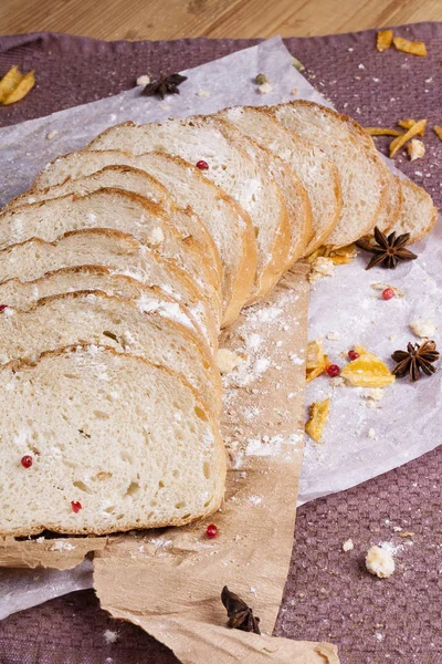Taze ve güzel kokulu beyaz ekmek dilimlenmiş ve bir ahşap zemin üzerine yalancı. Biraz baharat kendisine eklenmiş ve aynı zamanda kraft kağıt üzerinde yatıyor. Gluten-Alerjik. Kavramsal gıda fotoğraf.