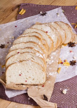 Taze ve güzel kokulu beyaz ekmek dilimlenmiş ve bir ahşap zemin üzerine yalancı. Biraz baharat kendisine eklenmiş ve aynı zamanda kraft kağıt üzerinde yatıyor. Gluten-Alerjik. Kavramsal gıda fotoğraf.
