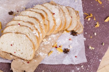 Taze ve güzel kokulu beyaz ekmek dilimlenmiş ve bir ahşap zemin üzerine yalancı. Biraz baharat kendisine eklenmiş ve aynı zamanda kraft kağıt üzerinde yatıyor. Gluten-Alerjik. Kavramsal gıda fotoğraf.