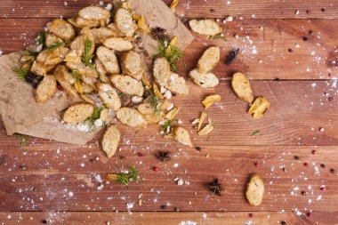 Huysuz ve güzel kokulu beyaz kruton kızarmış ve yalancı bir ahşap zemin üzerinde. Biraz baharat kendisine eklenmiş ve aynı zamanda kraft kağıt üzerinde yatıyor. Gluten-Alerjik. Kavramsal gıda fotoğraf.