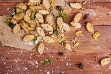 Huysuz ve güzel kokulu beyaz kruton kızarmış ve yalancı bir ahşap zemin üzerinde. Biraz baharat kendisine eklenmiş ve aynı zamanda kraft kağıt üzerinde yatıyor. Gluten-Alerjik. Kavramsal gıda fotoğraf.