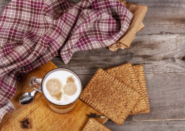 Ahşap bir masada bir fincan kapuçino.