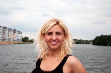 Portre, siyah t-shirt kameraya poz içinde oldukça gülümseyen sarışın