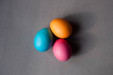 Mavi pembe turuncu renk ile gri bir arka plan üzerinde Paskalya yortusu yumurta