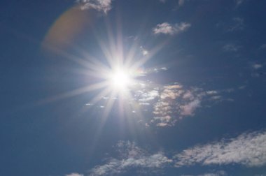 Bulutlar ve güneş ile mavi gökyüzü. Güçlü güneş, ilahi gökyüzü