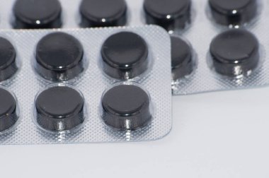 Aktif kömür, beyaz bir arka plan paketlenmiş Tablet