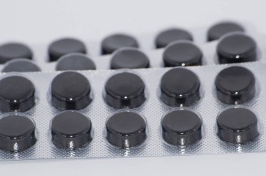 Aktif kömür, beyaz bir arka plan paketlenmiş Tablet