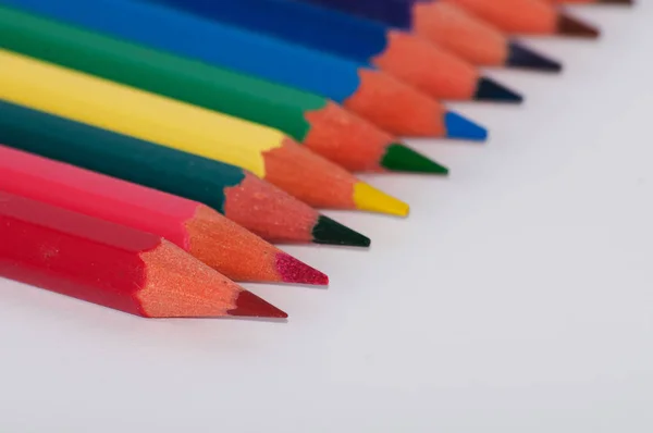 Crayons de couleur sur fond blanc gros plan, macro, vue de côté — Photo