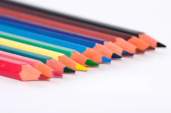 Muchos lápices de colores en un primer plano de fondo blanco, macro, vista lateral, con espacio para el texto . —  Fotos de Stock