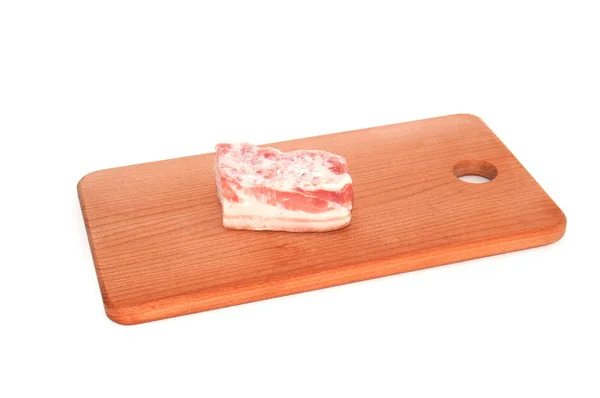 Vientre de cerdo congelado, pieza grande en una tabla de cortar —  Fotos de Stock