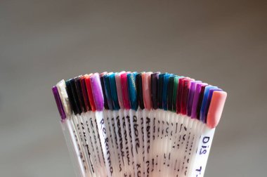 Gri bir arka plan üzerinde yapay sahte çivi. Güzellik Hizmetleri kavramı